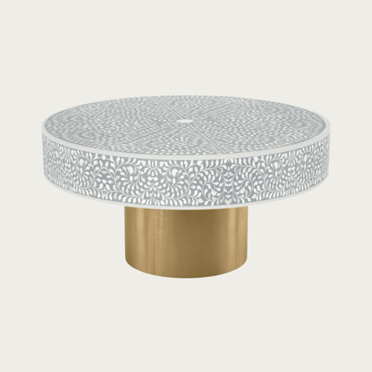 Round grey bone inlay coffee table featuring an intricate floral pattern and a bold gold base