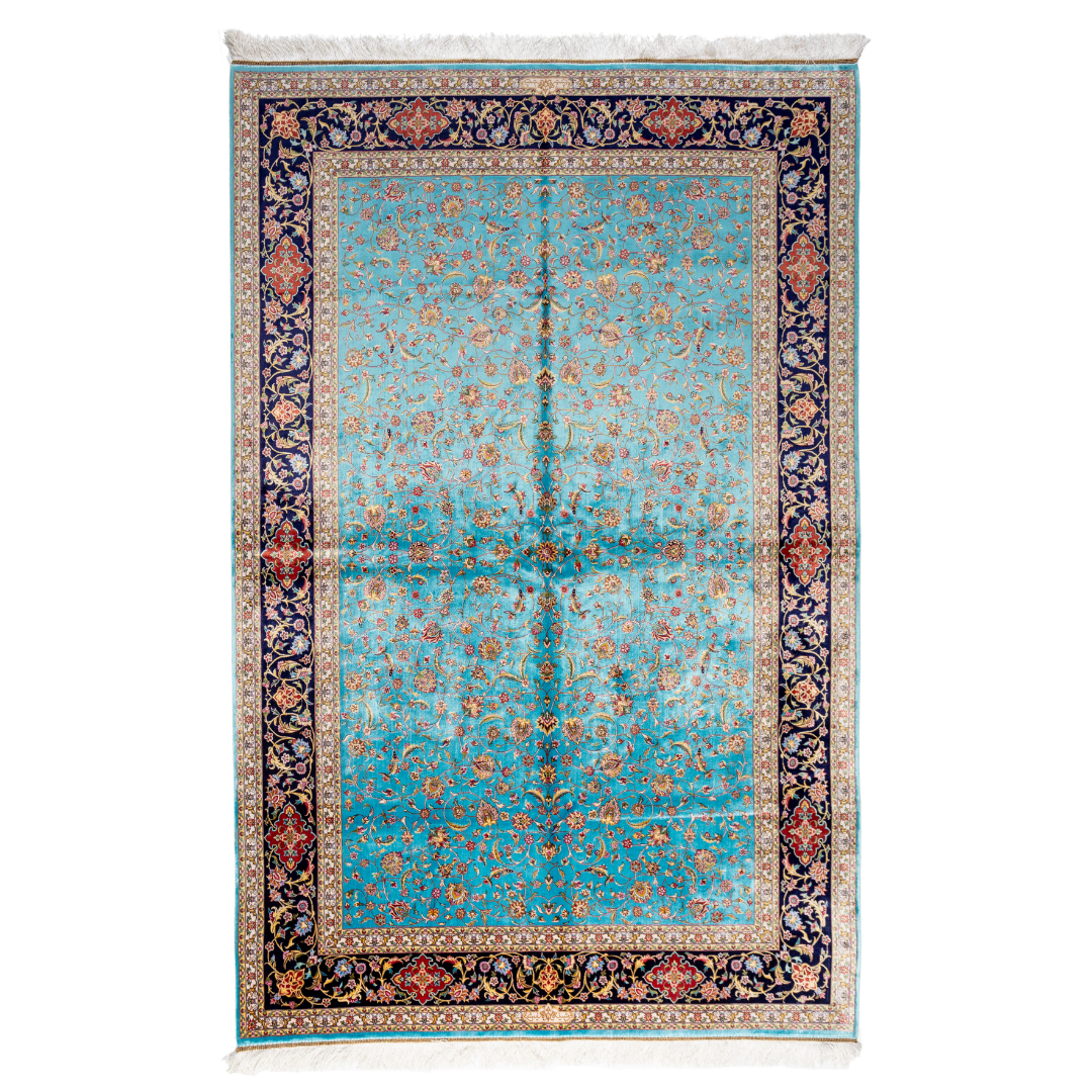 Aquamarine silk rug with coral and ivory floral motifs, framed by an indigo border. Handwoven with intricate detail and radiant sheen.

