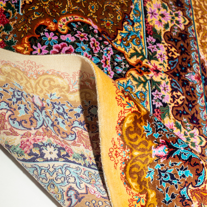 Luxurious silk rug featuring floral medallion pattern in gold, ivory, rose, and turquoise tones with intricate craftsmanship.