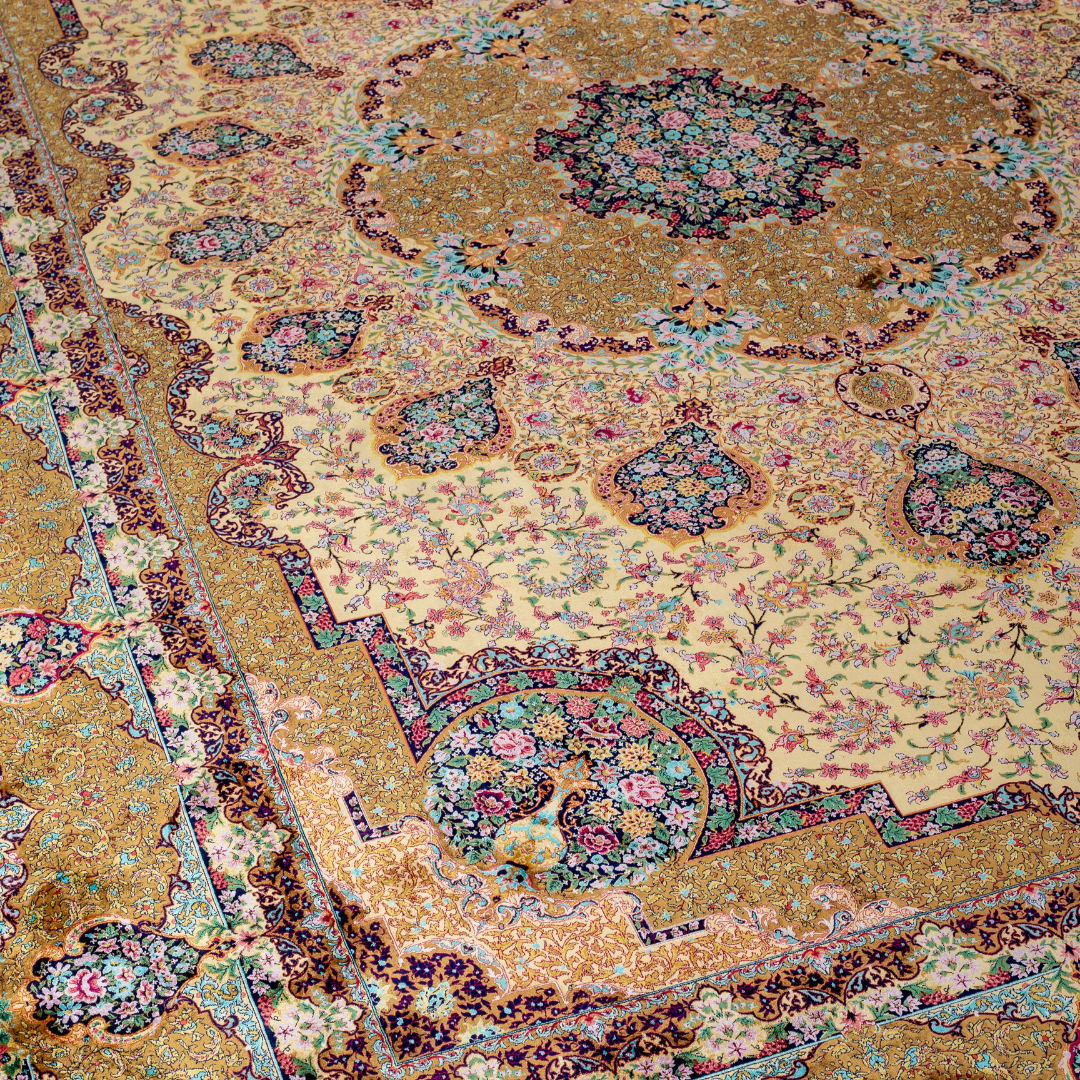 Luxurious silk rug featuring floral medallion pattern in gold, ivory, rose, and turquoise tones with intricate craftsmanship.