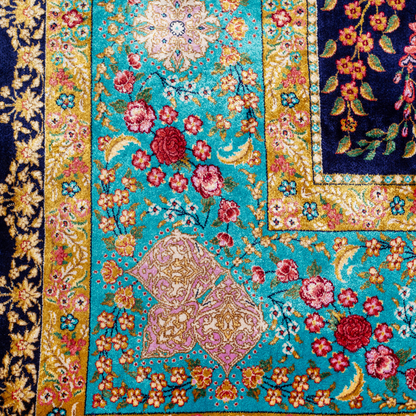 Silk rug in navy with crimson, pink, jade, and gold floral design. Tree-of-life motif. Size: 225x150 cm. Ships worldwide.