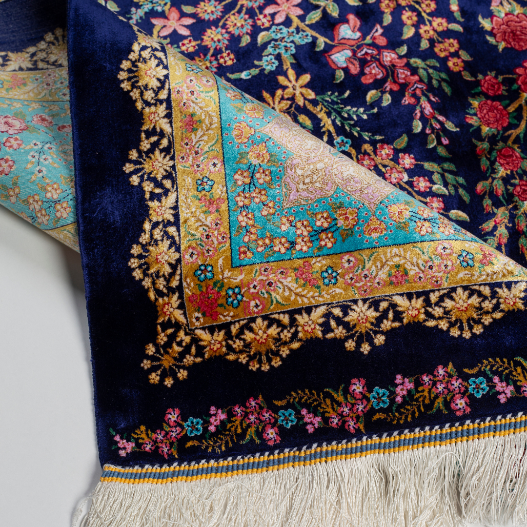 Silk rug in navy with crimson, pink, jade, and gold floral design. Tree-of-life motif. Size: 225x150 cm. Ships worldwide.
