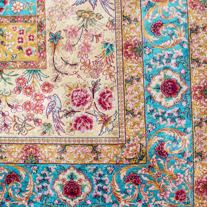 Tolly Silk Rug featuring ruby red floral and bird motifs on an aqua-blue base with golden ornate panels, size 150x100 cm.