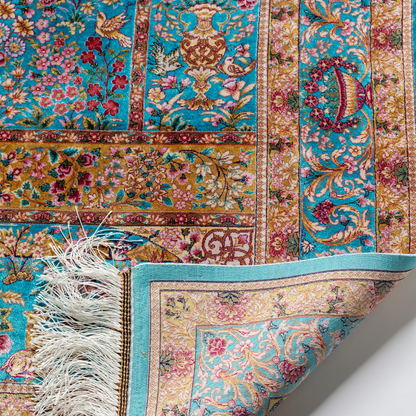 Tolly Silk Rug featuring ruby red floral and bird motifs on an aqua-blue base with golden ornate panels, size 150x100 cm.