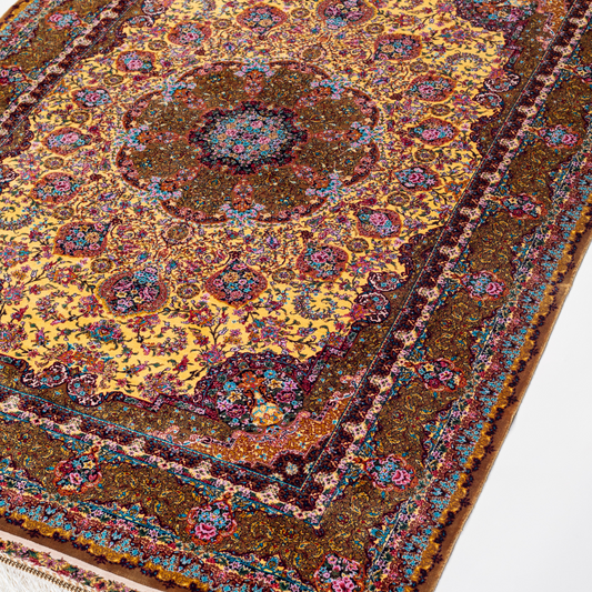 Golden silk rug with floral medallion center and wine-toned border, featuring intricate handmade detailing and vibrant color accents.
