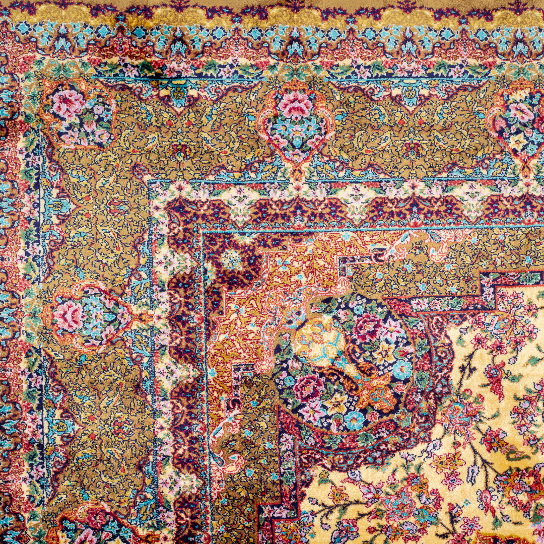 Golden silk rug with floral medallion center and wine-toned border, featuring intricate handmade detailing and vibrant color accents.
