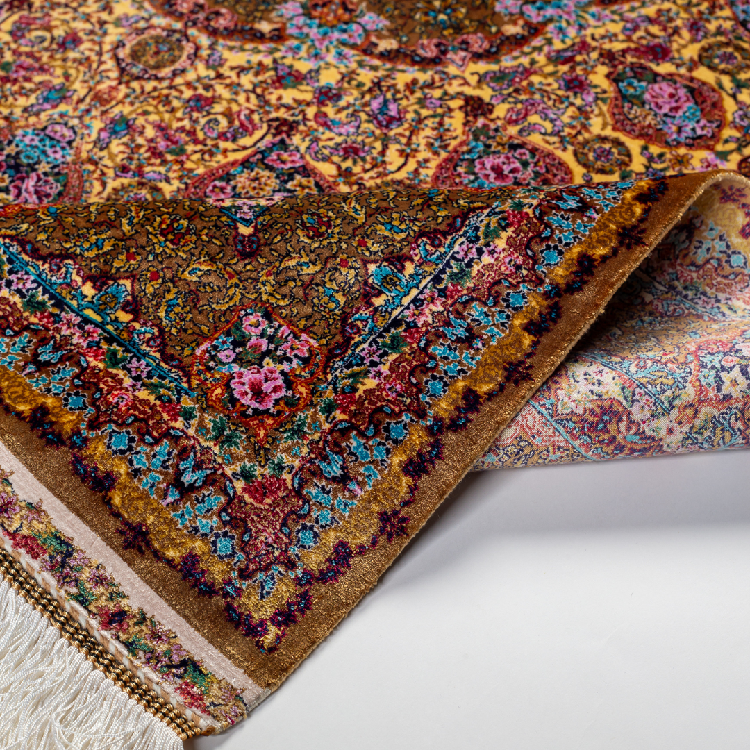Golden silk rug with floral medallion center and wine-toned border, featuring intricate handmade detailing and vibrant color accents.
