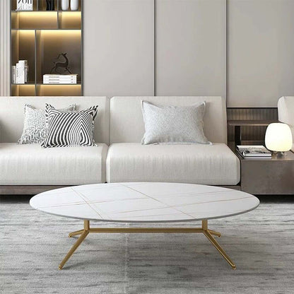 Oval white marble coffee table with subtle gold vein detailing and sleek gold legs