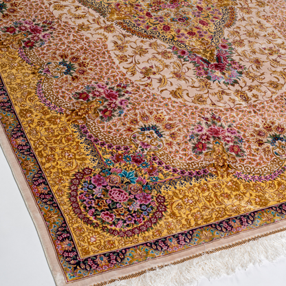 Handwoven silk rug in cream, gold, and blush tones featuring floral medallion, delicate vines, and ornate pastel detailing throughout.

