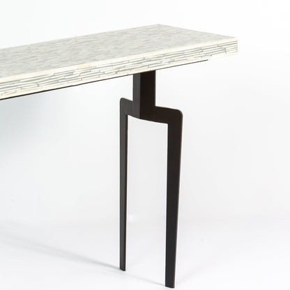 Table with a bone inlay top and black legs 