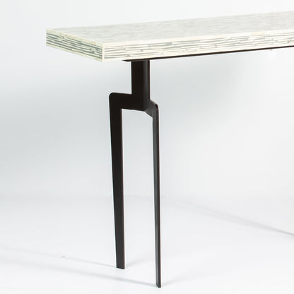 Minimalist table with a bone inlay top and black metal legs